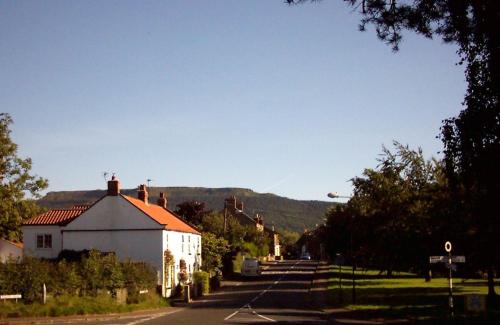 a street with a white house and a mountain at Wainstones Hotel in Stokesley