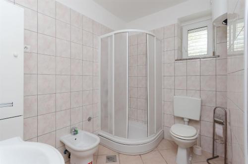 a bathroom with a shower and a toilet and a sink at Apartments Nada in Senj