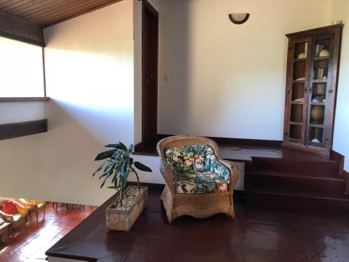 a living room with a chair and a potted plant at Pousada Encanto de Búzios in Búzios