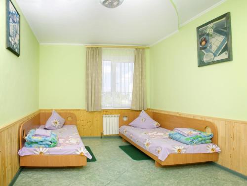 two twin beds in a room with a window at Galitsiya Hotel in Lviv