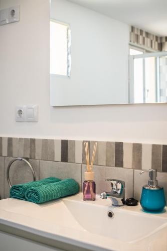 a bathroom sink with a green towel on it at Ocean View Penthouse in Gran Tarajal