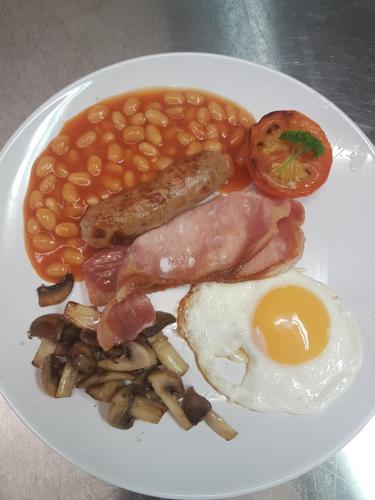 un plato de desayuno con huevos con judías y tocino en The Sea Croft Bed Breakfast & Bar, en Lytham St Annes