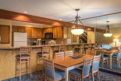 a kitchen with wooden cabinets and a table and chairs at Whispering Woods Resort, a VRI resort in Welches