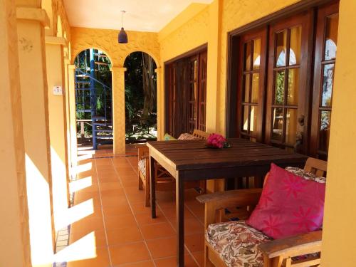 a porch with a wooden table and chairs at Reef View Pavilions - Villas & Condos in Lance aux Épines