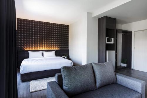 a bedroom with a bed and a couch at @S115 Residence in Samutprakarn