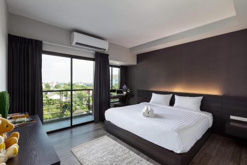 a bedroom with a large white bed and a large window at @S115 Residence in Samutprakarn