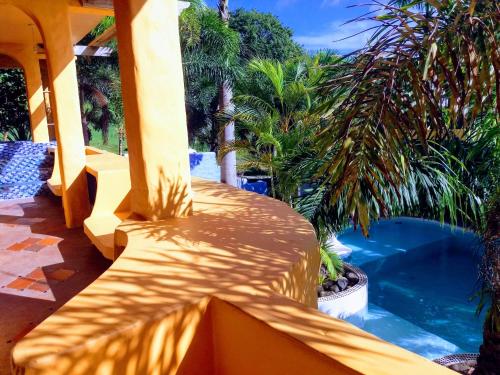 a patio with a swimming pool and palm trees at Reef View Pavilions - Villas & Condos in Lance aux Épines