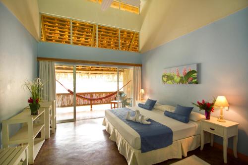 ein Schlafzimmer mit einem Bett und einem großen Fenster in der Unterkunft Villas del Caribe in Puerto Viejo