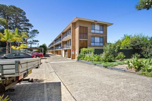 an apartment building with a car parked in the driveway at Aquarius Batehaven in Batemans Bay