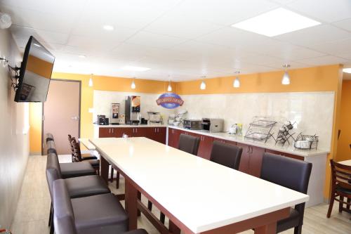 a large kitchen with a long table and chairs at Baymont by Wyndham Plano in Plano