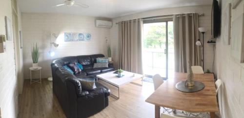 a living room with a couch and a table at Aquarius Batehaven in Batemans Bay