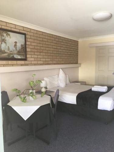 Una cama o camas en una habitación de Jolly Swagman Motor Inn