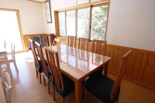 a dining room with a wooden table and chairs at Guest House Chaconne Karuizawa in Karuizawa