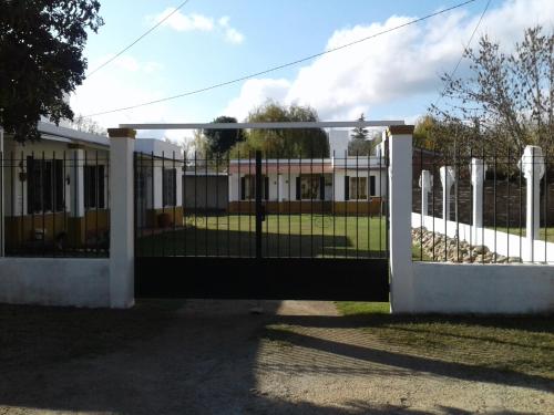 um portão aberto para um edifício com uma cerca em La Colonial Cabañas em Villa Cura Brochero