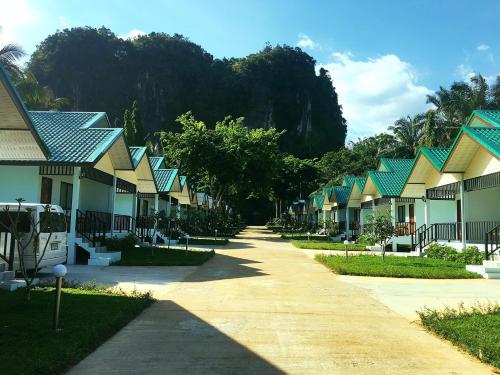 uma fila de casas com telhados verdes e amarelos em Changsi Resort-Krabi em Krabi
