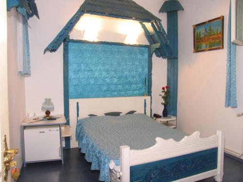 1 dormitorio con 1 cama con dosel azul en Pensiunea Ana Maria, en Târgu Mureș