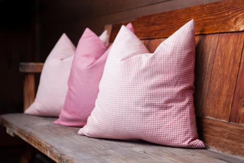 three pink and white pillows sitting on a bench at Apart Tyrol in Uderns