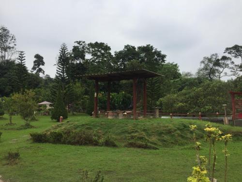 a gazebo in the middle of a grass field at Happy Paradise in Kampung Janda Baik