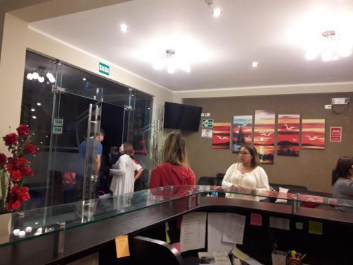 a group of people standing in a waiting room at Gavina Inn Hotel in Tacna