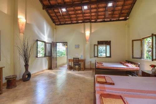 a large room with two beds and a table at Dudhsagar Plantation in Cormonem