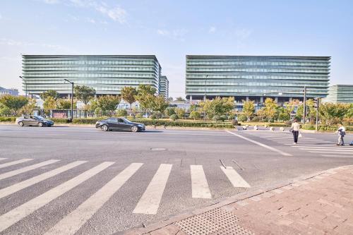 a parking lot with cars on a street with buildings at Plesant Daily Rental Apartment in Hangzhou