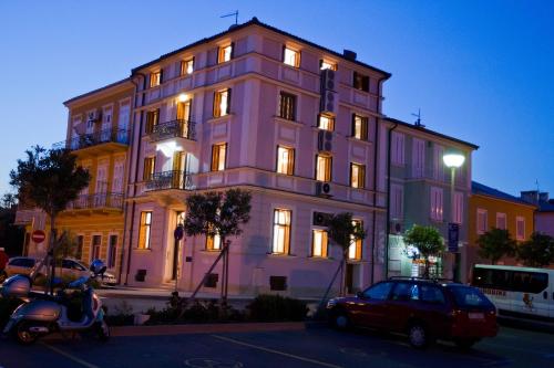 a scooter parked in front of a large building at Apartments Villa Castello in Crikvenica