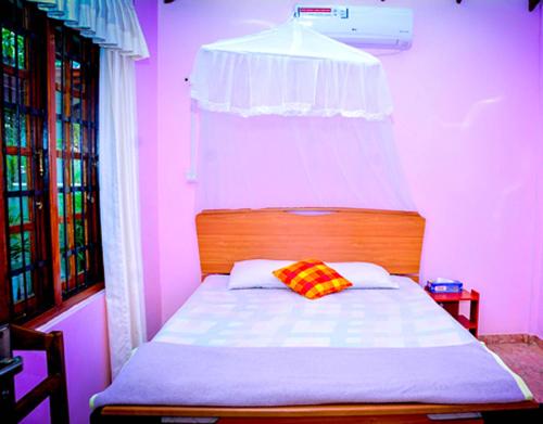 a bedroom with a bed in a pink room at Villu Villa in Anuradhapura