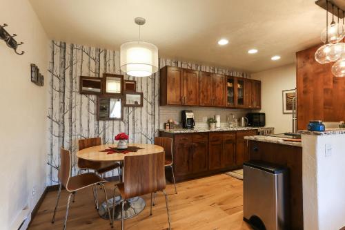 a kitchen with a wooden table and a kitchen with a refrigerator at POW HAUS: Modern Beaver Creek 2BR w/ Ski Access in Avon