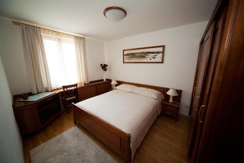 a bedroom with a bed and a desk and a window at Apartments Villa Castello in Crikvenica