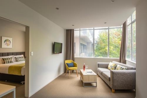 um quarto de hotel com uma cama e um sofá em Quest on Hobson Serviced Apartments em Auckland