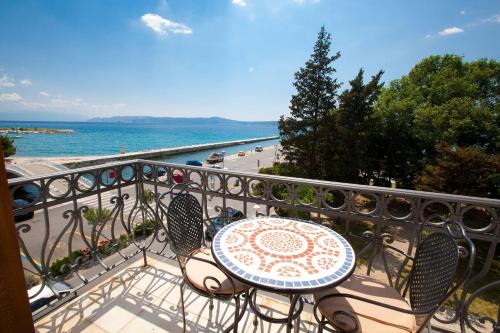 a table and chairs on a balcony overlooking the ocean at Apartments Villa Castello in Crikvenica
