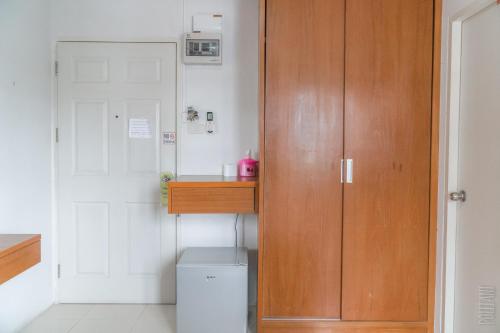 a bathroom with a wooden cabinet next to a toilet at Noble U-house Chiangmai in Chiang Mai