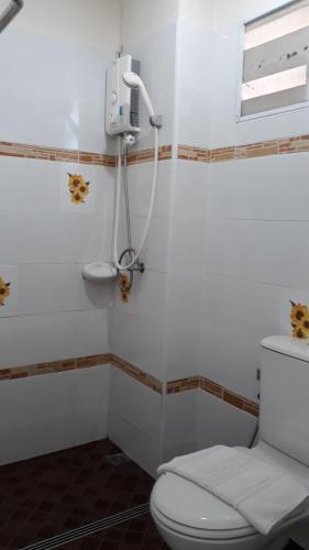 a bathroom with a white toilet and a sink at Chumphon Travelodge in Chumphon