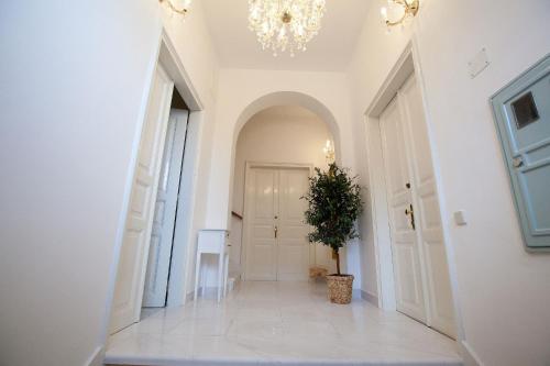 a hallway with a chandelier and a potted plant at Apartments Villa Castello in Crikvenica