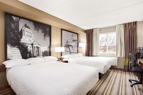 En eller flere senge i et værelse på Super 8 by Wyndham Winnipeg West