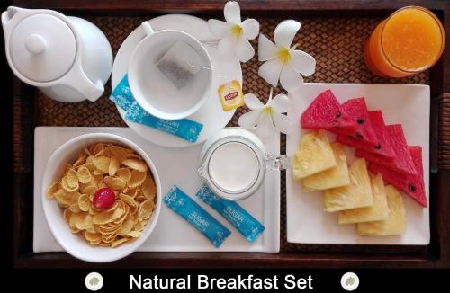 ein Tablett mit Frühstücksspeisen und einer Schüssel Müsli in der Unterkunft Chor Chang Villa Resort in Strand Choeng Mon