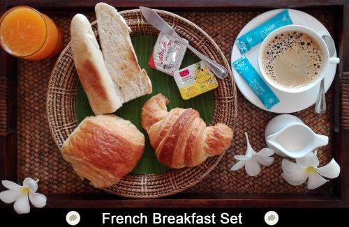 ein Tablett mit Brot, einer Tasse Kaffee und Blumen in der Unterkunft Chor Chang Villa Resort in Strand Choeng Mon