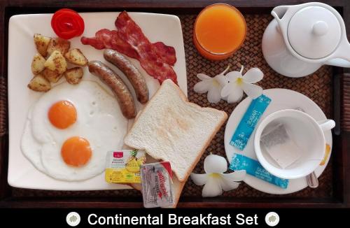 ein Tablett mit Frühstücksspeisen, Eiern, Speck, Toast und Kaffee in der Unterkunft Chor Chang Villa Resort in Strand Choeng Mon