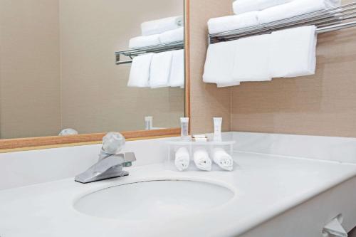 a bathroom with a sink and a mirror and towels at Howard Johnson by Wyndham Torrance in Torrance