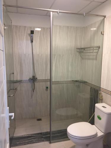 a bathroom with a glass shower with a toilet at HD House in Noi Bai