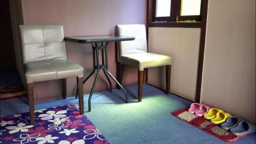 a room with two chairs and a table and some shoes at Happy Paradise in Kampung Janda Baik