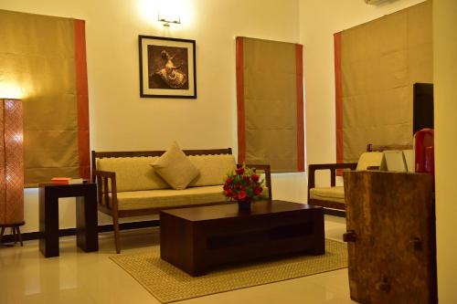 a living room with a couch and a coffee table at Niraamaya Wellness Retreats, Surya Samudra, Kovalam in Kovalam