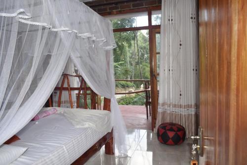 a bedroom with a bed with a mosquito net at Ella Rock Glance in Ella
