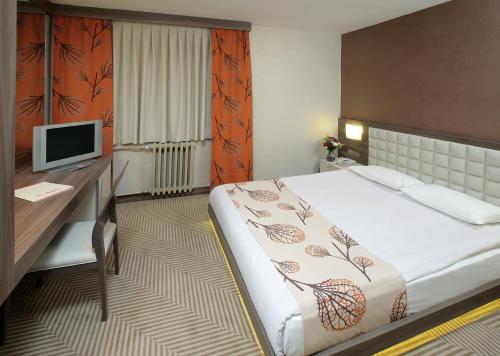 a bedroom with a bed and a desk with a computer at Dorukkaya Ski & Mountain Resort in Kartalkaya