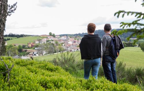 two men standing on a hill looking at a village at André et Viviane Chatelard - Chambres d'hôtes in Saint-Bonnet-le-Froid