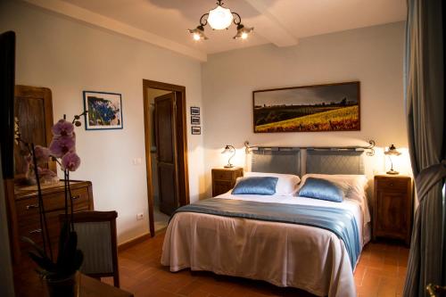 a bedroom with a bed and a painting on the wall at Castellinuzza in Greve in Chianti