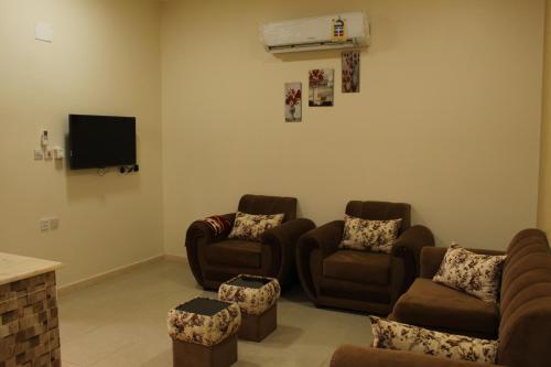 a living room with couches and a flat screen tv at AL Ibdaa Compound Furnished Apartments in Baish