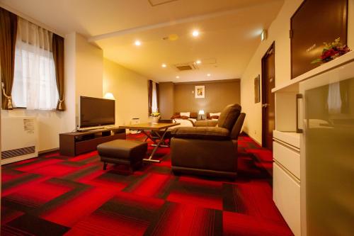a living room with a table and chairs and a television at Condominium Stella Site in Hakodate