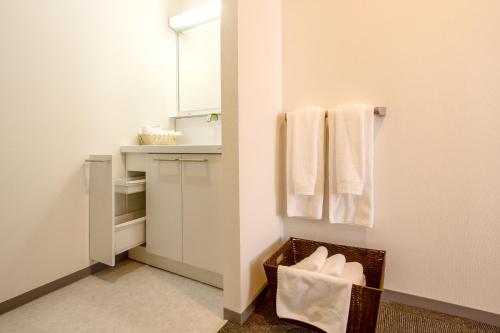 a small bathroom with white towels and a sink at Condominium Stella Site in Hakodate