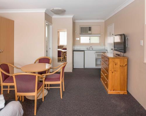 a room with a table and chairs and a kitchen at Katoomba Town Centre Motel in Katoomba